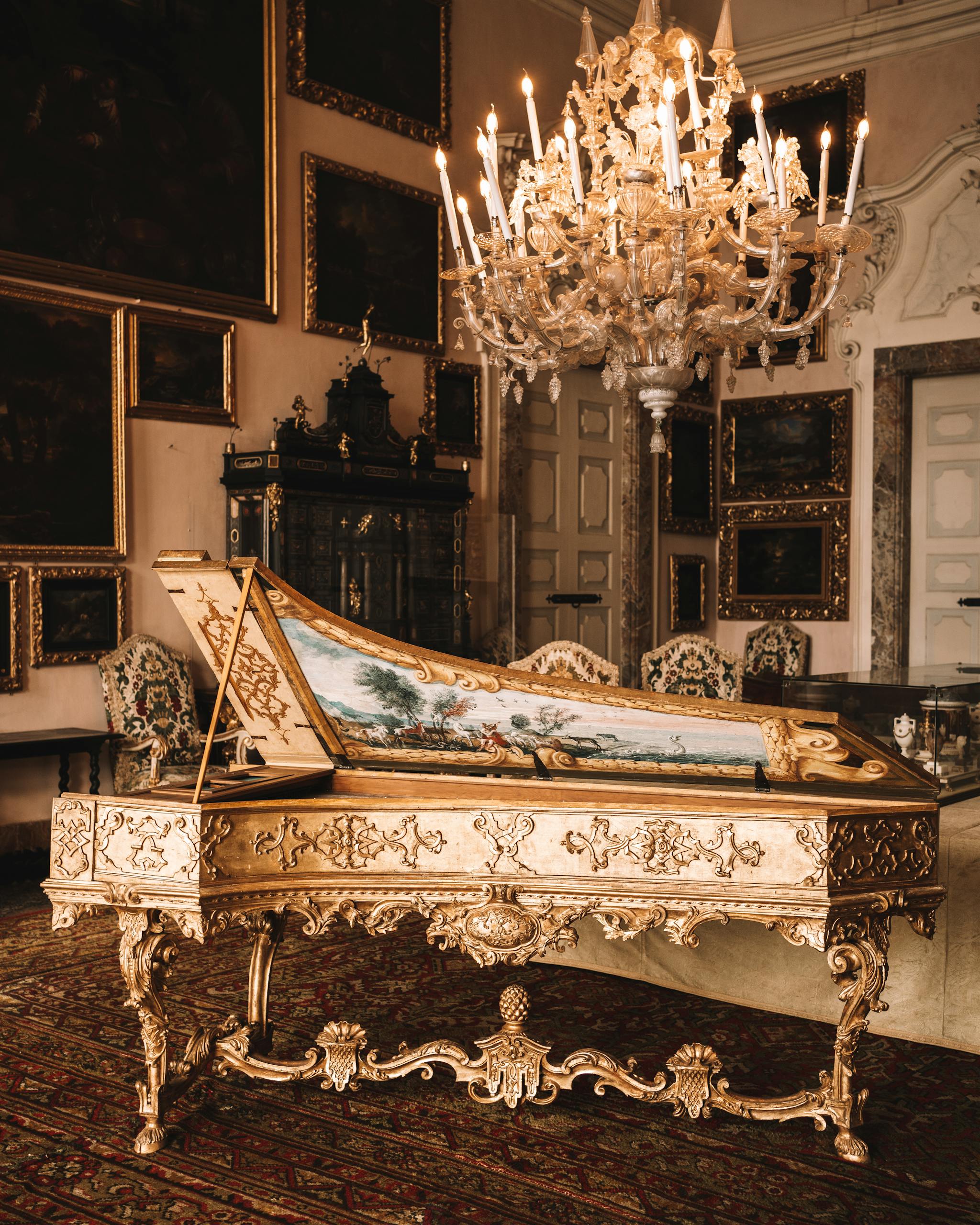 Elegant interior of Isola Bella's villa featuring ornate piano and chandelier in Stresa, Italy.